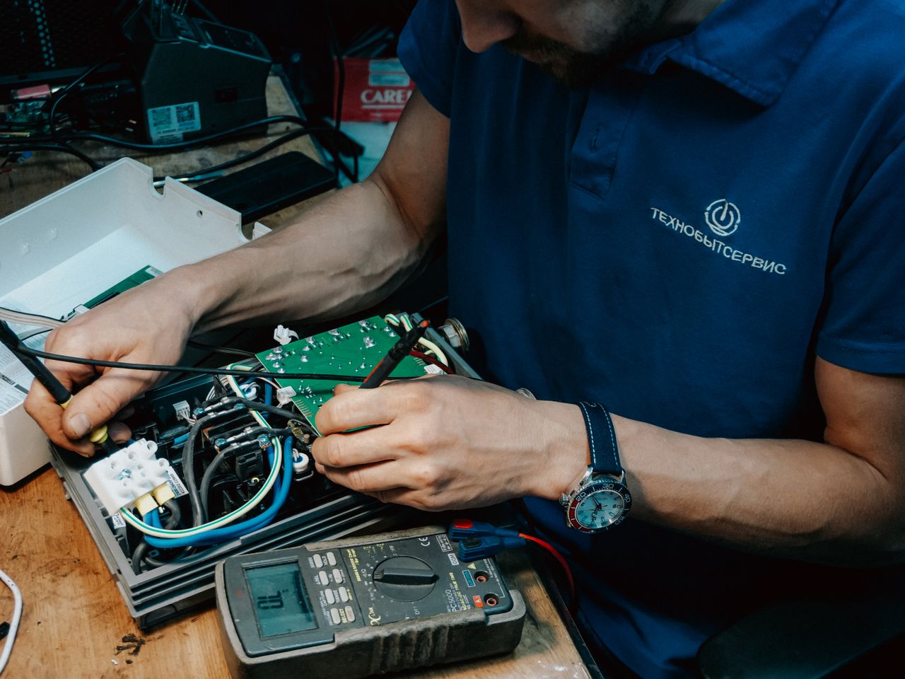A technician methodically repairs a circuit board, showcasing expertise in electronics and technical skills.